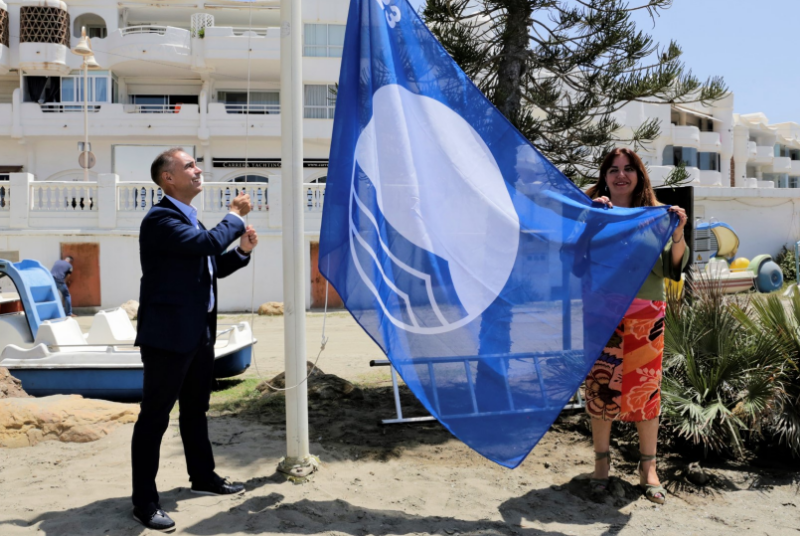 EL ALCALDE , JUAN ANTONIO LARA, IZÓ AYER LAS BANDERAS AZULES OBTENIDAS POR LAS PLAYAS DE MALAPESQUERA Y FUENTE DE LA SALUD